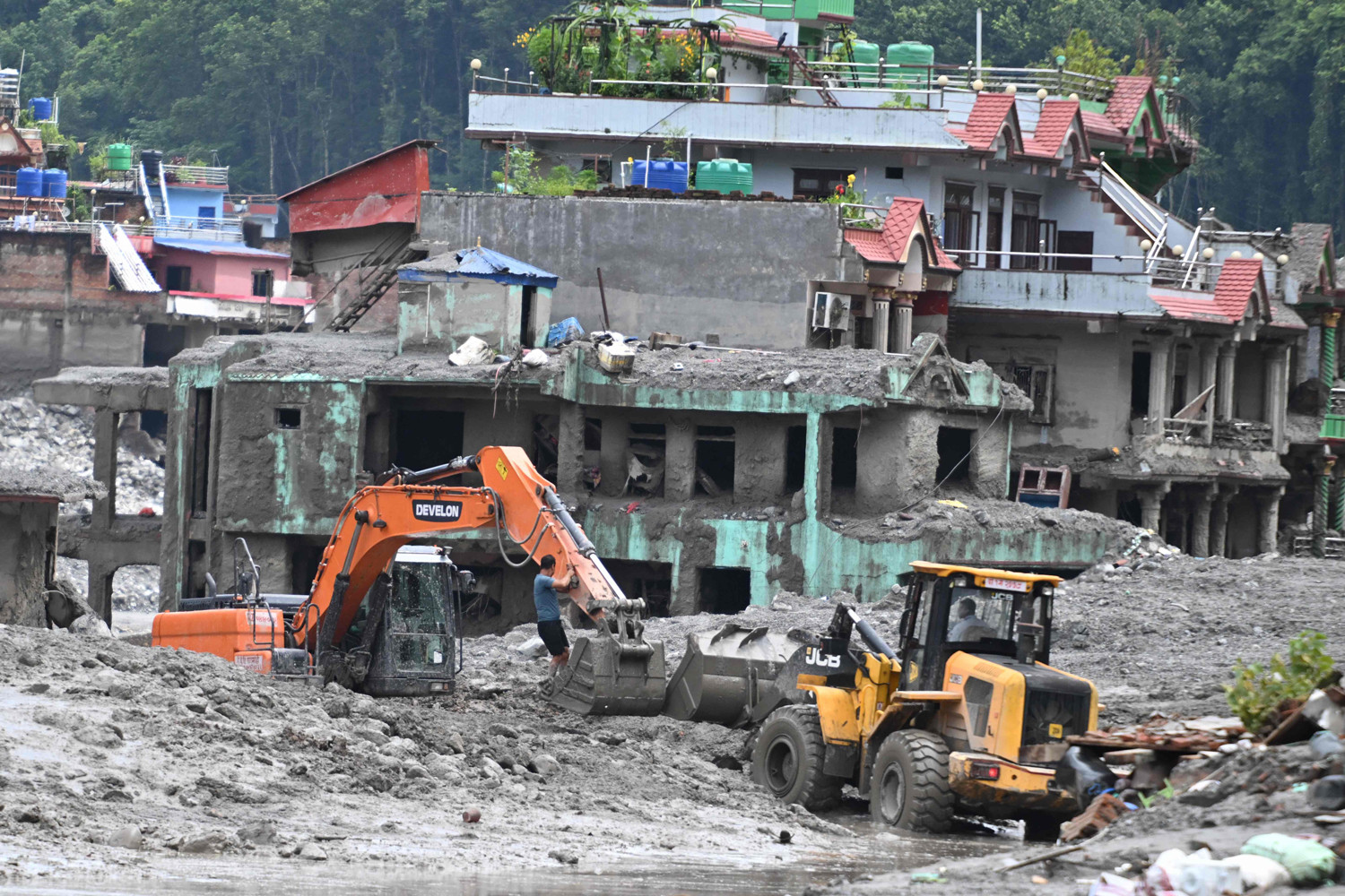 Nepalin Nuwakot bölgesinde Trishulide meydana gelen sel baskını ve heyelanın ardından bir ekskavatör (solda), insanların evlerinden eşyalarını toplamalarına yardımcı oluyor. Fotoğrafın da çekildiği 29 Ağustos tarihi itibariyle yaklaşık 3 bin kişi hala kayıp ve Nepal-Tibet sınırını vuran ani seller ve toprak kaymalarının ardından en az 633 kişinin ise yaşamını yitirdiği doğrulandı. (Fotoğraf: AFP)